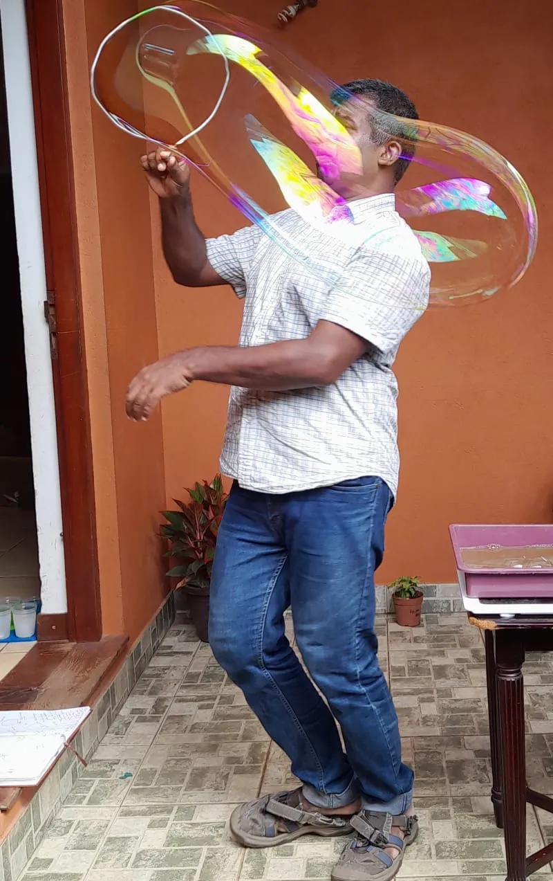 Mr. N standing inside a huge soap bubble he has just lifted around himself
