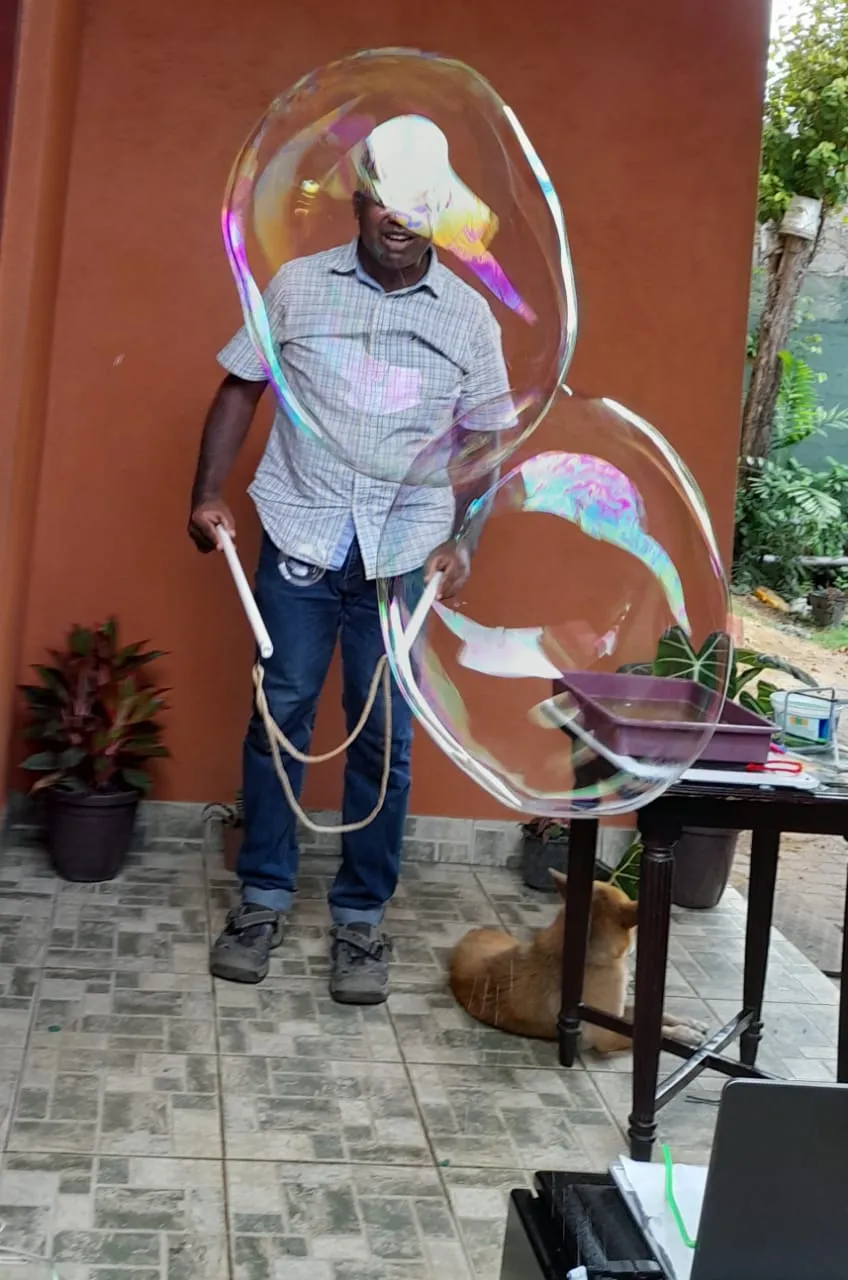 Mr. N making two enormous soap bubbles with rope wands