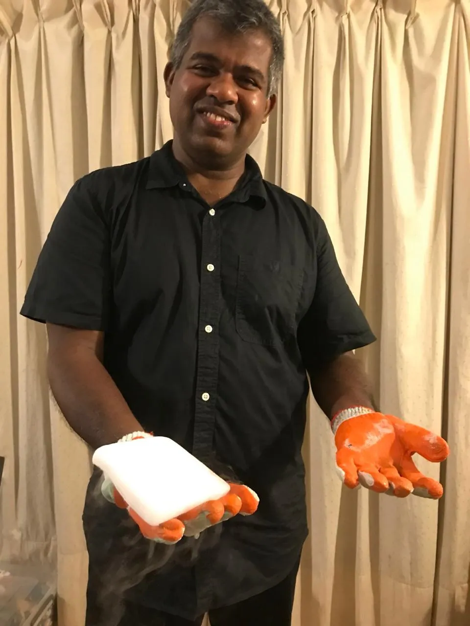 Mr. N holding a smoking block of dry ice in insulated gloves